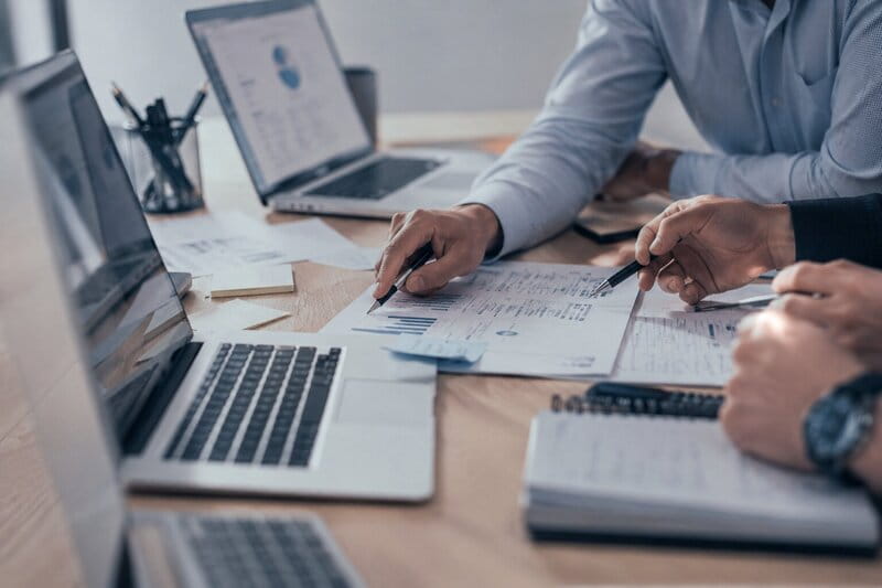 Reunión de consultoría con portátil y gráficos empresariales